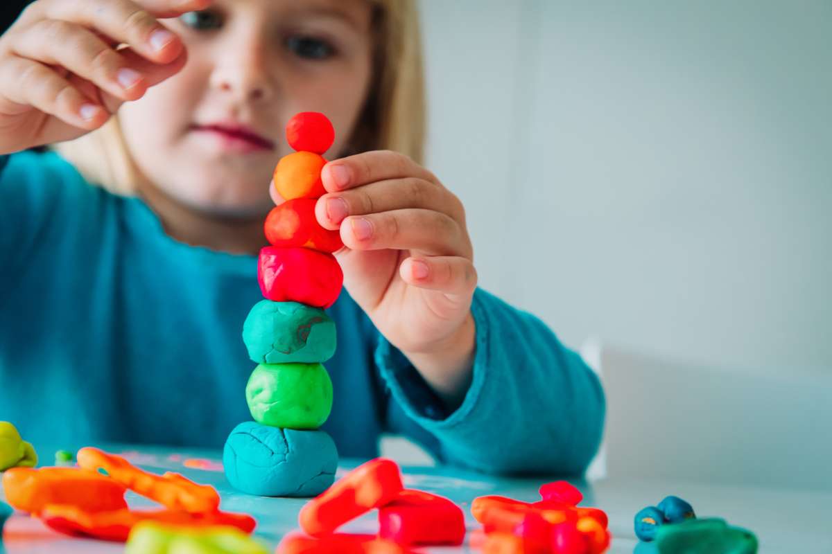 a-hand-holding-a-small-toy-with-food-on-it